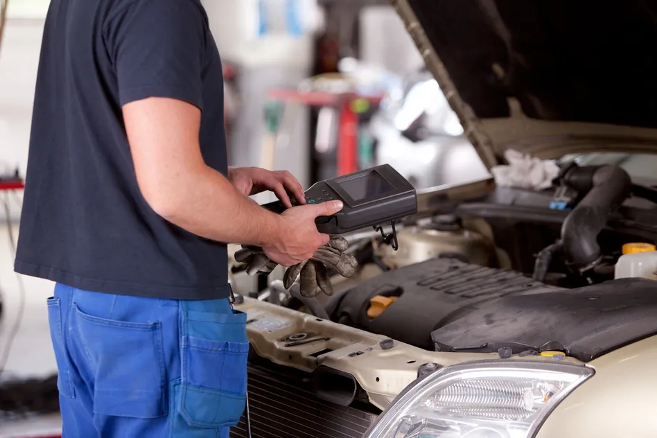 Mechanic using diagnostic equipment
